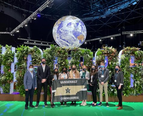 Vanderbilt students posing with a flag at the COP26 conference