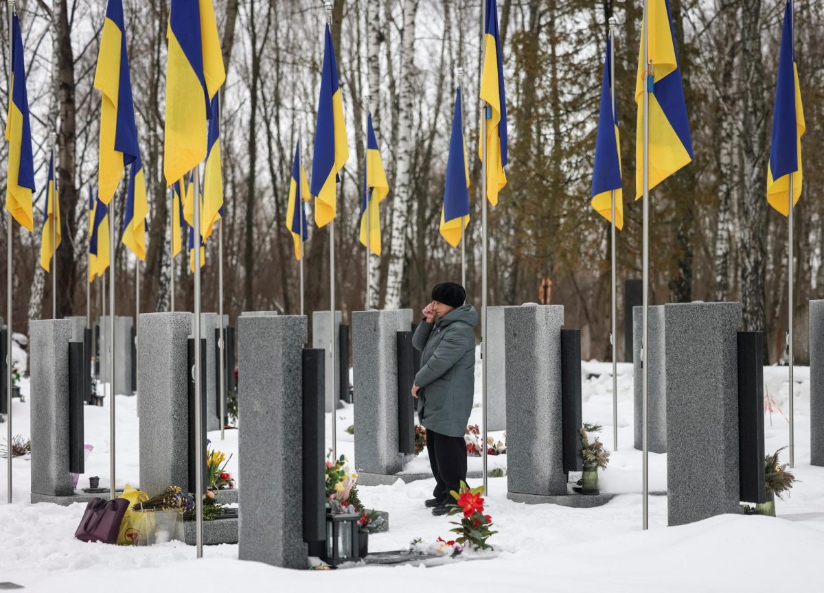 A woman reacts as she stands in front of a grave at a local cemetery, as she pays tribute to the victims of the Russian attack on Ukraine, on the day marking the fourth anniversary of the full-scale Russian invasion, in Chernihiv, Ukraine February 24, 2026. REUTERS/Maksym Kishka